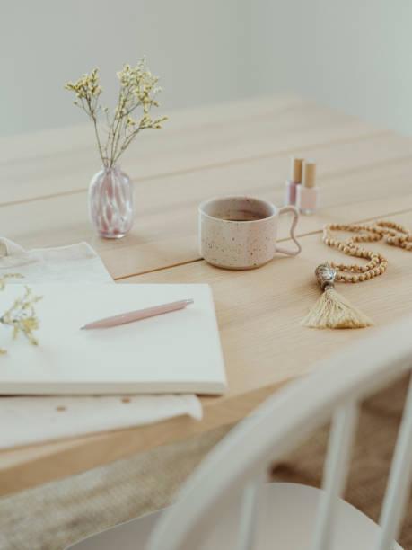 istock Modern still life at home coffee cup note book zen buddha necklace and pen on table 1462595796