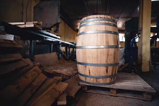 Close-up of old barrels in wine cellar. Barrels lie horizontally on stands.