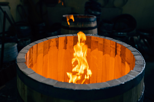 Close-up of an oak barrel burning, to gain aroma for the alcohol which will be stored in it