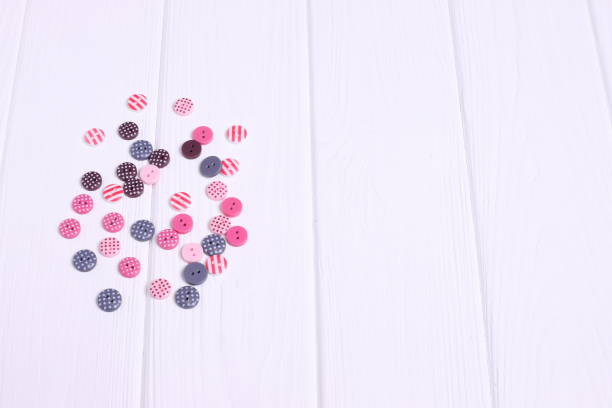 Group of colorful buttons for sewing on wooden table