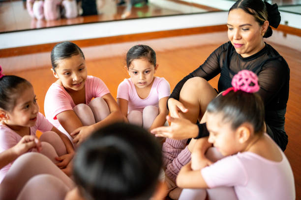 Ballet students sitting on a circle at the dance studio