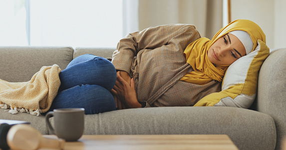 Depression, sofa and sad Islamic woman with mental health problem, anxiety and emotional pain in Arabic home living room. Medical healthcare crisis, lonely and Muslim girl depressed over fail mistake