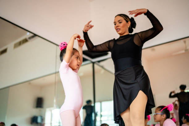 istock Girl ballet dancer being assisted by teacher at the dance studio 1462613200