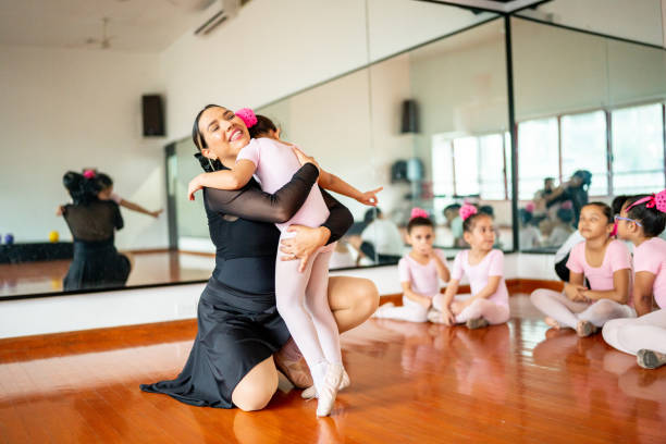 istock Girl ballet dancer being hugged by teacher at the dance studio 1462613302