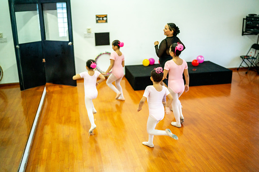 Ballet girls getting out of the dance studio with teacher