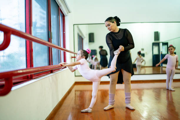istock Ballet teacher assisting girl to stretch at a dance studio 1462613812