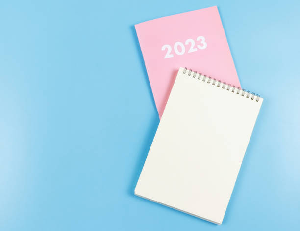 istock flat lay of blank paper note book on pink diary 2023 on blue  background. 1462613828