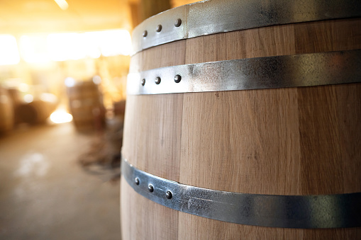 Close-up of oak barrel with metal hoops at the workshop