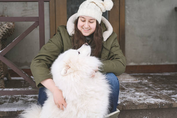 young woman with samoyed dog outdoors in winter