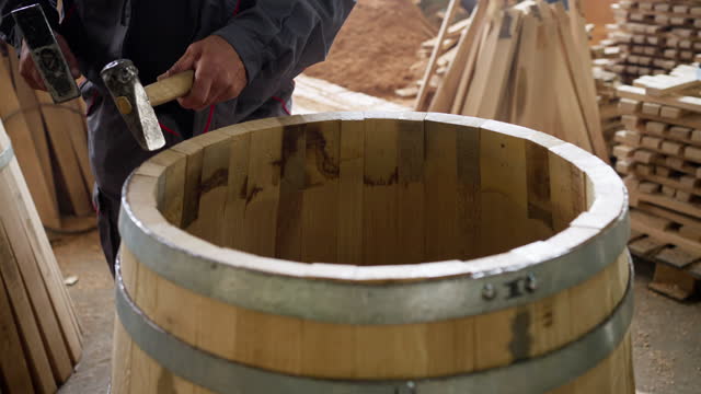 Cooper making barrel from oak wooden steves