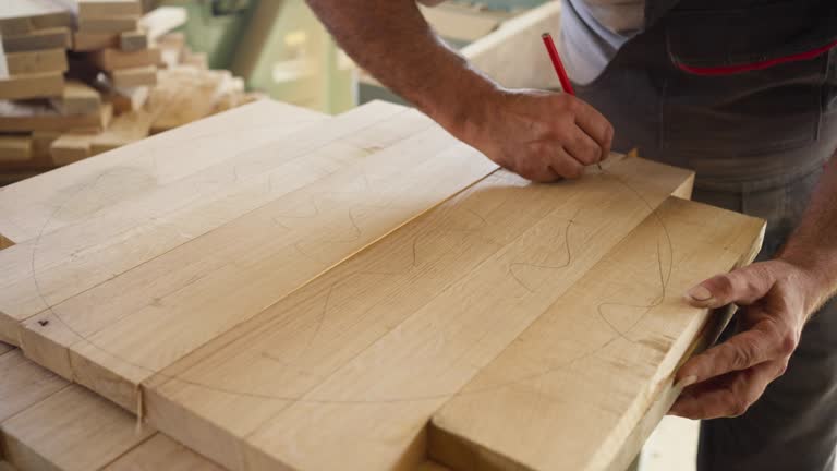 Cooper using pen to draw a circle on a oak wood while making barrel