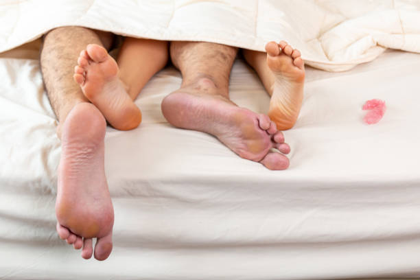 Couple just finished make love by using condom for protecting pregnant or birth control. Conscious sexual life, using condom for protection. Using contraception condom while having sex in bed. la pareja acaba de terminar de hacer el amor usando condón para proteger a las embarazadas o anticonceptivos. vida sexual consciente, usando condón para protegerse. usar condón anticonceptivo mientras tiene relaciones sexuales en la cama.