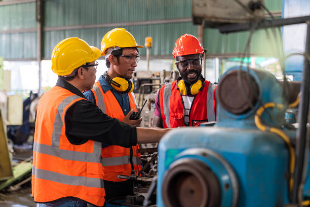 istock Metal worker teaching trainee on machine. Engineer men wearing uniform safety in factory. Team Of Engineers Having Discussion In Factory 1462627952