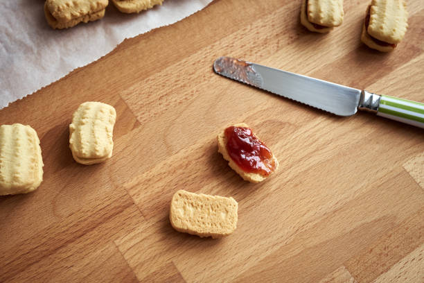 Preparation of traditional Christmas cookies - filling with strawberry marmalade