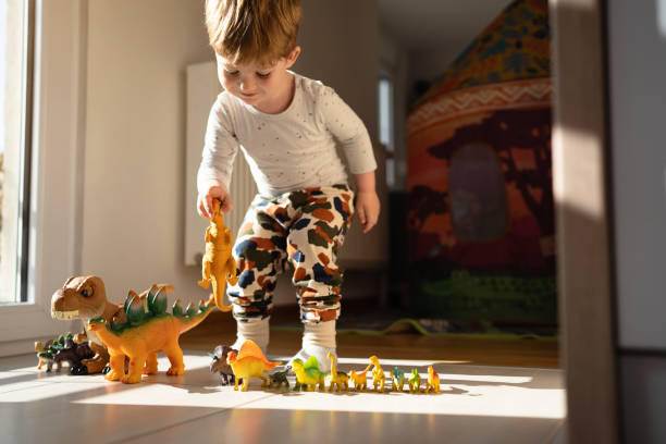 niño caucásico jugando con juguetes de dinosaurios - version 2 fotos fotografías e imágenes de stock