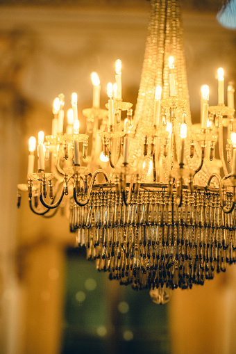 Beautiful Crystal Chandelier. Close up on the crystal of a contemporary crystal decoration. Luxury luster in the banquet hall. Great close-up photo of crystal chandelier on the blue background. Glamour crystal glass in modern room.