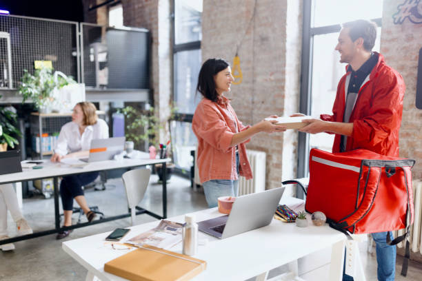 istock Woman taking pizza from a delivery guy 1462637905
