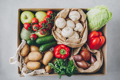 Vegetables. Organic food box delivery. Tomatoes, potatoes, cucumbers, radish, basil, onions, paprika, lettuce. Fresh farm veggies.