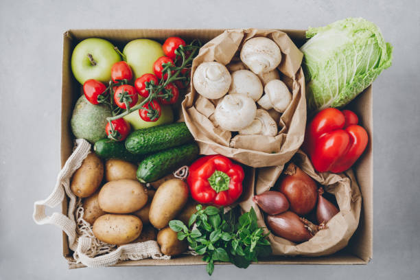 Vegetables. Organic food box delivery. Tomatoes, potatoes, cucumbers, radish, basil, onions, paprika, lettuce. stock photo