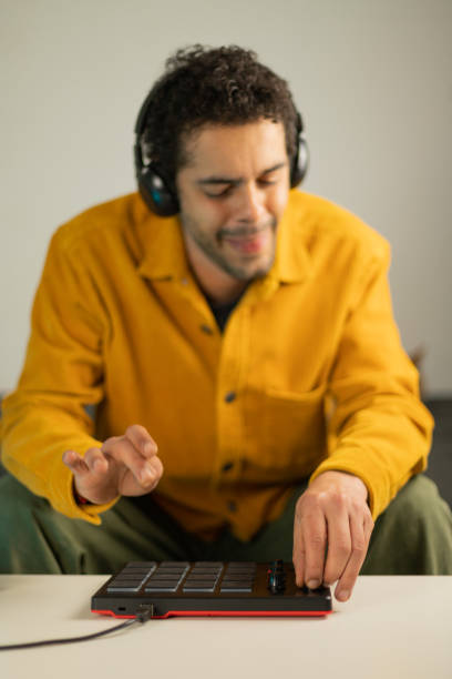 istock Mixed race man making beats from his sofa at the coffee table with an MPD MIDI controller 1462648620