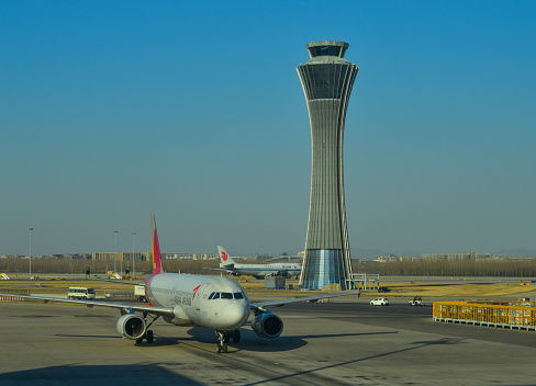 Beijing, China - Mar 1, 2018. An aircraft with control tower at Terminal 3 of Beijing Capital Airport (PEK), China.
