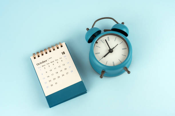 istock October 2023 desk calendar with alarm clock on blue background 1462655527