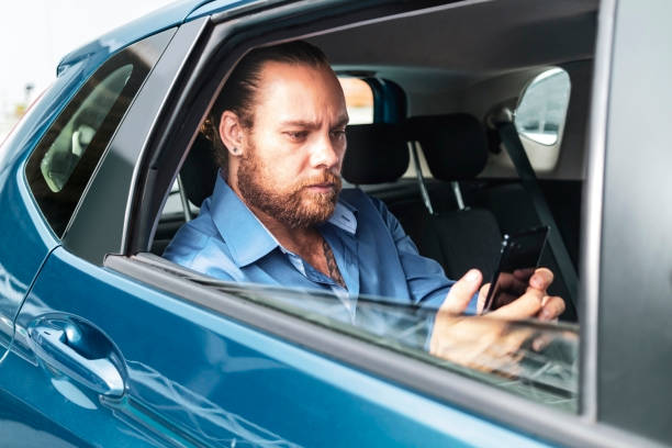 istock Businessman in a car using smartphone. 1462655964