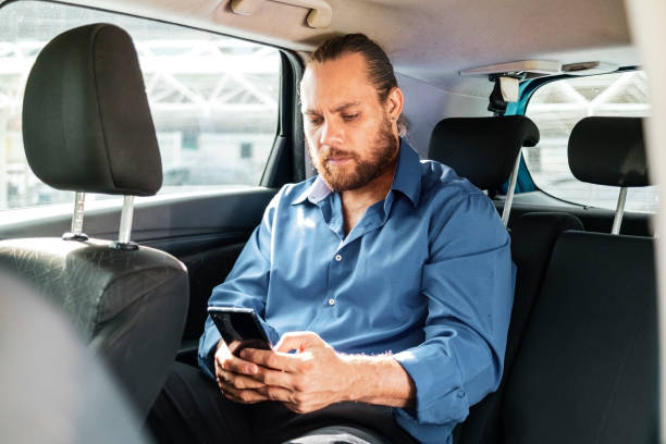 istock Businessman in a car using smartphone. 1462655970