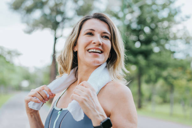 portrait d’une femme sportive souriante - exercising running women jogging photos et images de collection