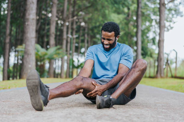 Man in pain during exercise Man in pain during exercise hugging knees stock pictures, royalty-free photos & images