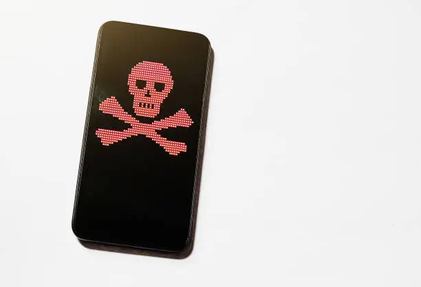 Mobile phone screen displays the skull and crossbones, representing danger, failure or perhaps a hacked device. ASCII art done by the photographer, so there is no third-party copyright and this image may be used without restrictions.