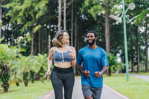 公共の公園を走る友人のカップル - running jogging african descent nature ストックフォトと画像