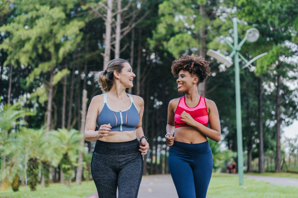 dos amigas corriendo juntas - sostén deportivo fotografías e imágenes de stock