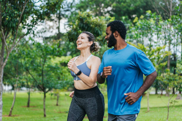 公共の公園を走る友人のカップル - running jogging african descent nature ストックフォトと画像