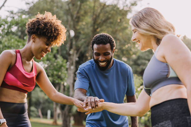 istock Group of active mature friends in park stacking hands after workout 1462659750