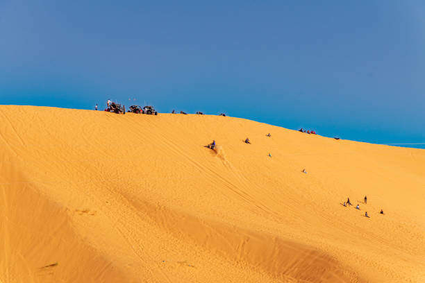 tomar el sol y montar un quad en una duna de arena. - off road vehicle quadbike 4x4 stationary fotografías e imágenes de stock