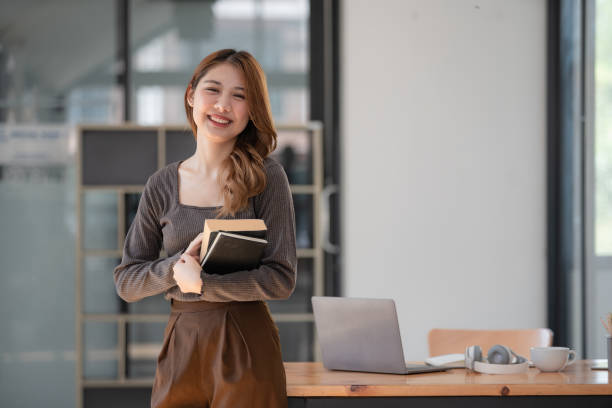 istock Pretty young Asian college student standing while holding books. Back to school concept. 1462663047