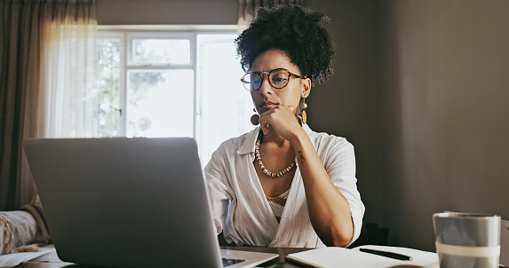 Thinking, planning and black woman work from home, online research and brainstorming ideas for career on laptop. Worker, person or entrepreneur typing, writing and digital strategy for creative job