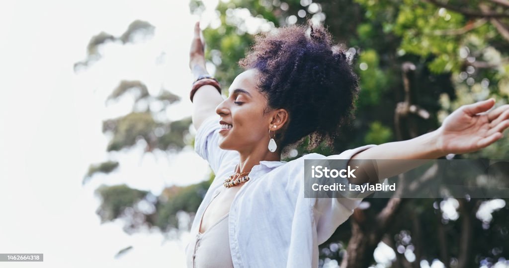 Zen, freedom and black woman with open arms, nature and peace with smile, balance and joyful outdoor. African American female, lady or meditation for fresh air, carefree or celebration with happiness Mental Health Stock Photo