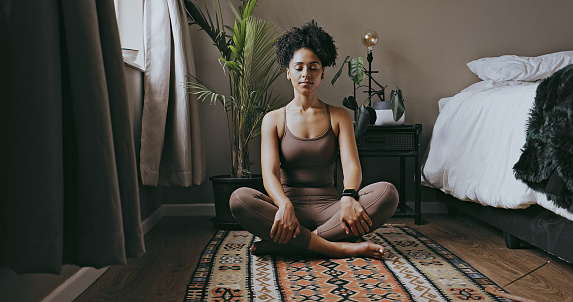 Zen, relax and mediation with black woman and yoga in bedroom for calm, peace and morning routine. Wellness, breathing and balance with health girl training at home for spiritual, healing and energy