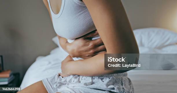Menstruation Stomach Ache And Hands Of Woman In Bedroom For Indigestion Cramps And Illness Frustrated Gas And Stress With Girl On Bed For Constipation Bloating And Intestine Problems At Home Stock Photo - Download Image Now