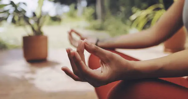 Mudra exercise, woman and yoga meditation for mental health, freedom and chakra energy in garden, park and zen. Closeup girl, hands and meditate in lotus outdoors for wellness, hope and calm mindset