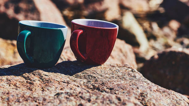 istock Red green ceramic cups for coffee tea beverages on a rocky sunny stones 1462664541