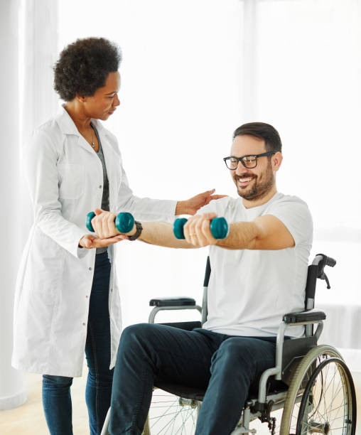 istock disability wheelchair disabled man handicap exercise training home dumbbell physical therapy recovery therapist doctor nurse rehab lifting weight 1462665589