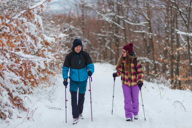 istock Two young hikers talking to each other while climbing up a snowy mountain 1462665888