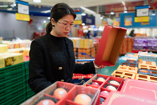 Asian women are picking fruits in store