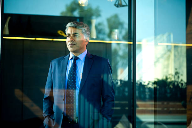 istock Thoughtful businessman looking through glass window 1462666301