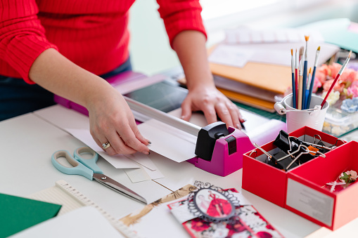 Talented female designer creating beautiful scrapbooks. DIY, hobby concept, gift idea