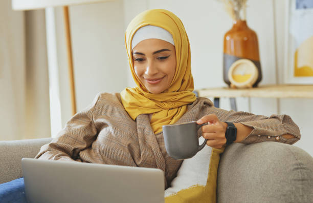 Home laptop, coffee and relax Muslim woman working remote on feedback review of Arab stock market investment. Islamic, finance economy and crypto trader happy for bitcoin, NFT or forex trading profit computadora portátil en casa, café y relajarse mujer musulmana que trabaja a distancia en la revisión de la retroalimentación de la inversión en el mercado de valores árabe. comerciante islámico, financiero y criptográfico feliz por el comercio ele