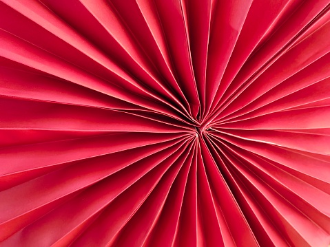 Red origami decoration. Photo taken against a blurred background.